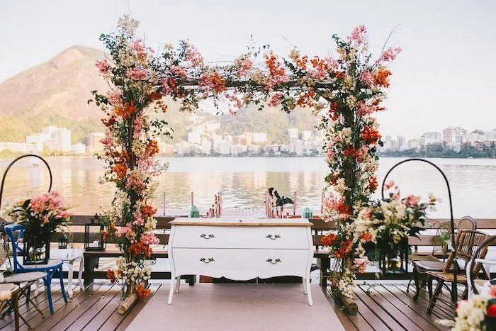 pink and red flowers arch, antique white dresser, aisle leading to the lake, wedding decoration ideas