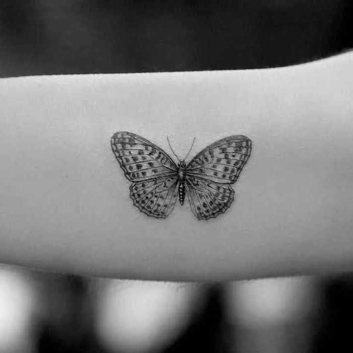 butterfly tattoo on the forearm, tattoo ideas for women, black background