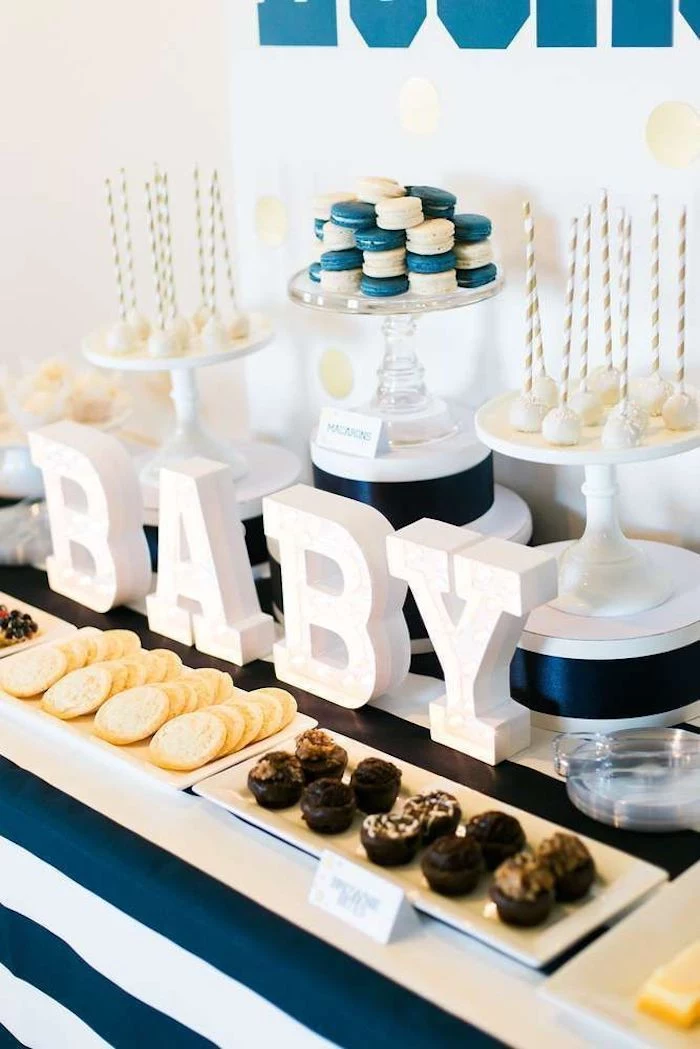 blue and white macaroons, baby shower ideas for boys, baby wooden letters, cookies and sweets on the table