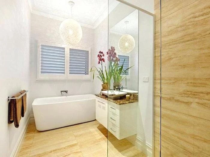 beige tiled walls and floor, white bathtub, white floating cabinets, how to decorate a small bathroom