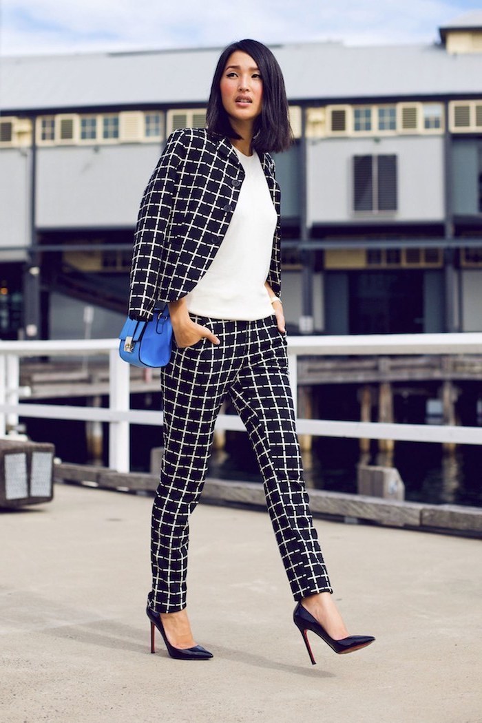 business attire for women, black and white stripe trousers and blazer, white top, black shoes, blue bag