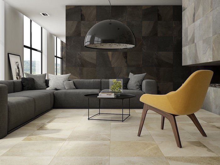 yellow chair, wall treatments, grey corner sofa, white and black stone tiles on the walls