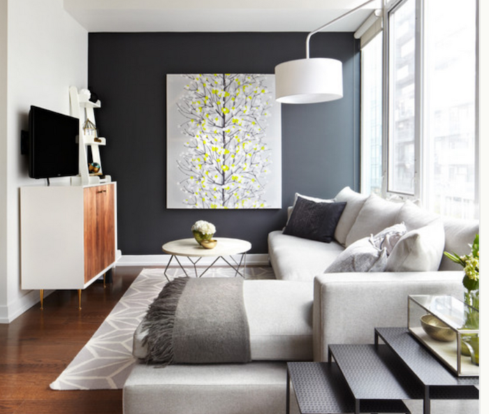 black wall with a grey and yellow painting, white corner sofa, accent wall living room, white and grey rug