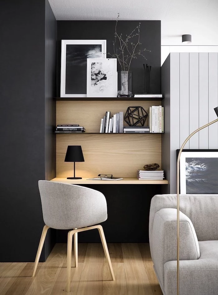 black wall, wooden bookshelves, office design, grey chair, desk lamp