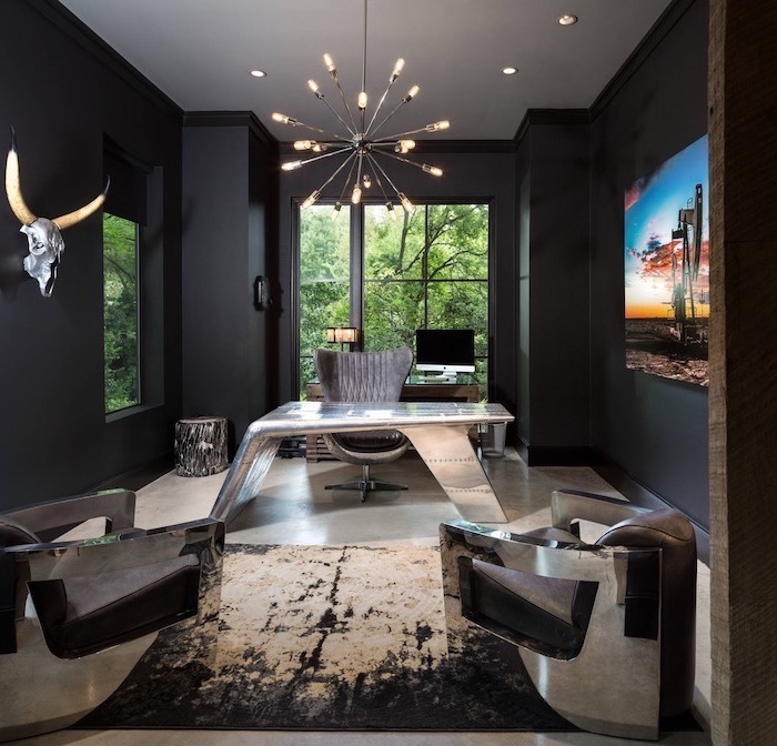 black walls, hanging metal chandelier, metal desk, large velvet grey armchair, small office ideas
