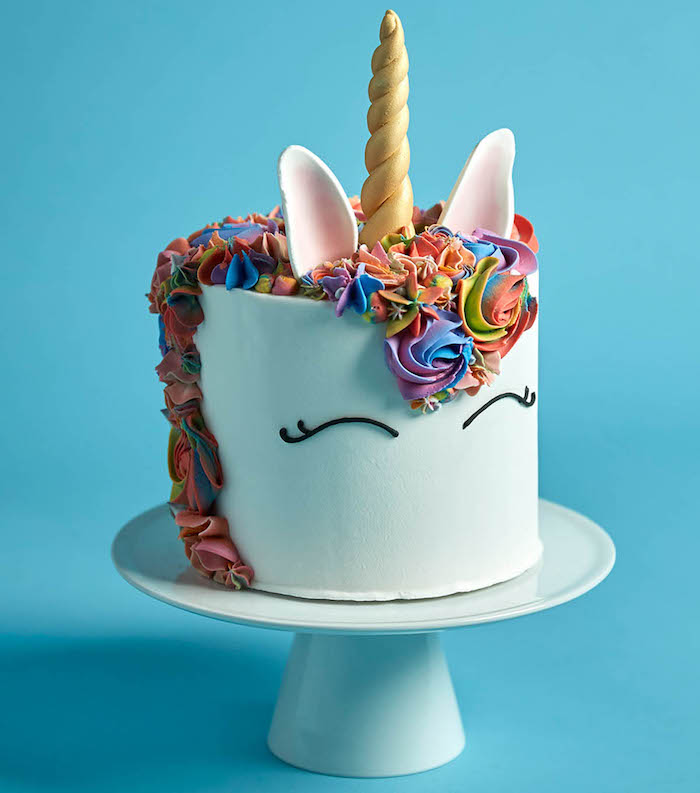 rainbow coloured roses, blue background, unicorn cake ideas, white cake stand
