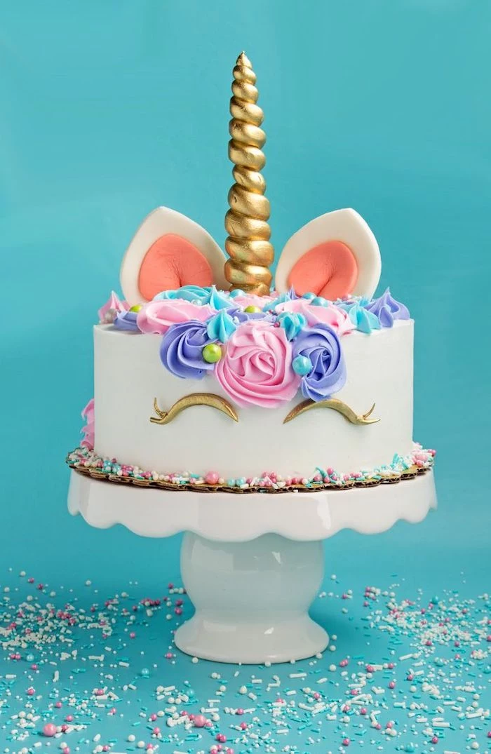 sprinkles on the blue countertop, how to make a unicorn cake, pink purple and blue roses on white fondant