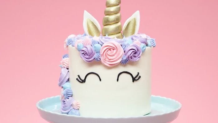 blue cake stand, rainbow unicorn cake, pink blue and purple roses on white fondant, gold horn and ears