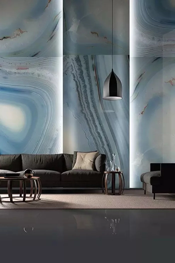 blue marble tiled wall with lights, living room wall colors, black sofa and armchair, hanging lamp