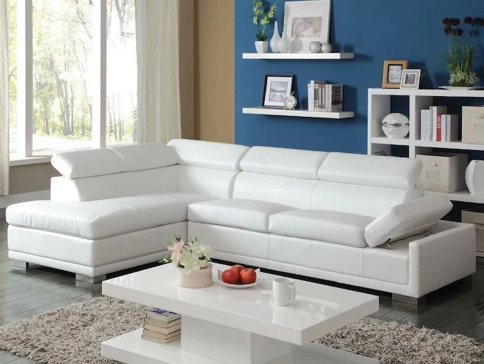 white corner sofa, blue wall with white bookshelves, dining room wall decor, white coffee table