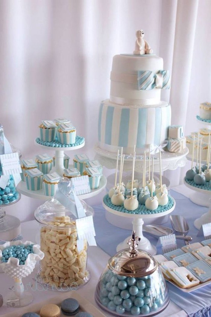white and blue cake and sweets on the table, baby shower party ideas, jars of candy,