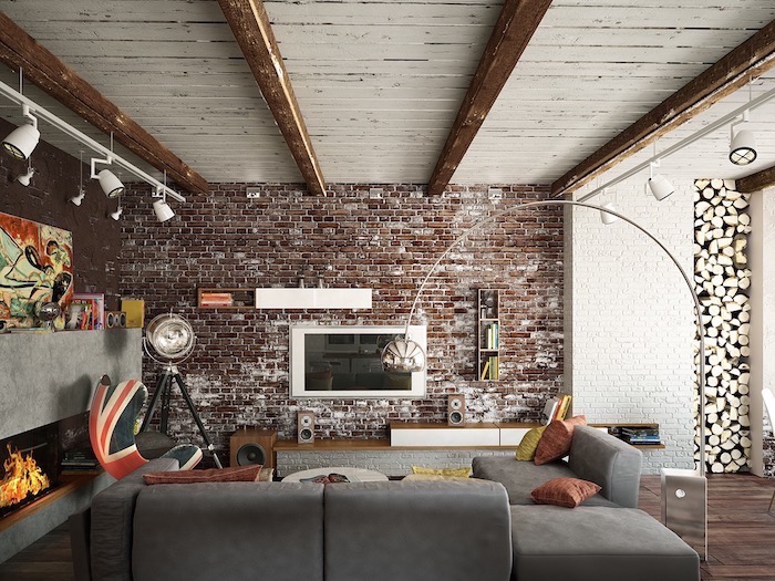 brick wall, grey corner sofa, accent wall, uk flag printed armchair, wooden floor and a fireplace