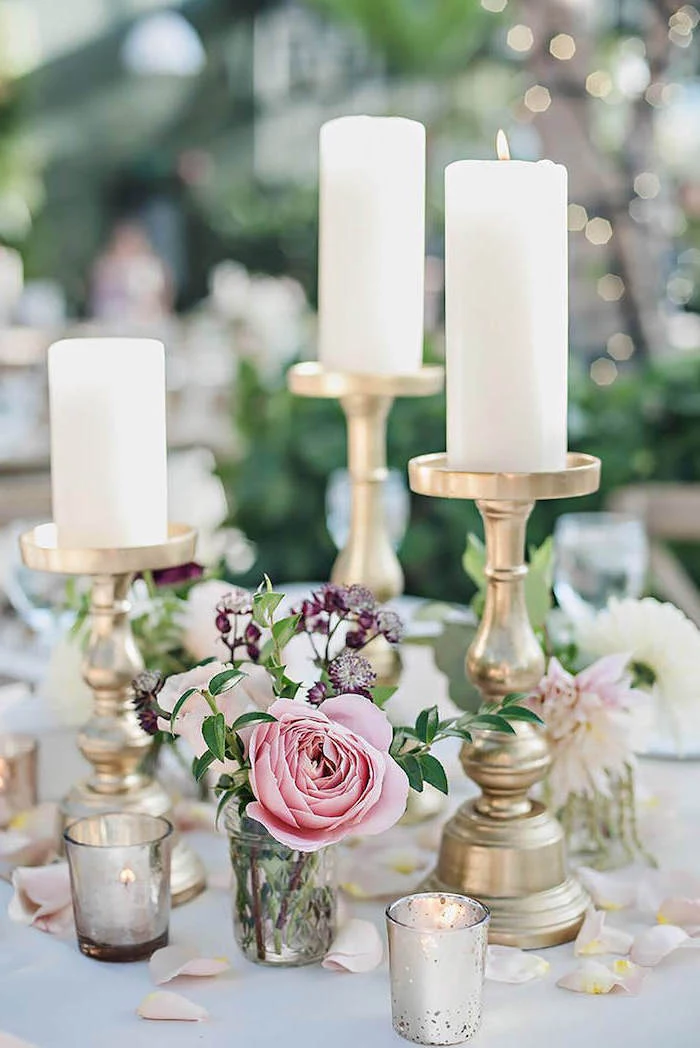 candlesticks with candles, rose petals on the table, white and pink roses flower bouquet in a small vase, diy wedding decorations