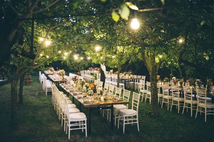 hanging string lights, yellow and orange flower bouquets on the tables, wedding decor
