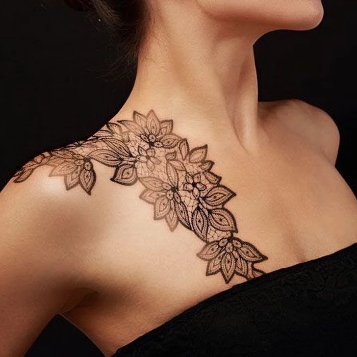 chest tattoos for females, symmetrical flowers on the shoulder, black top and background
