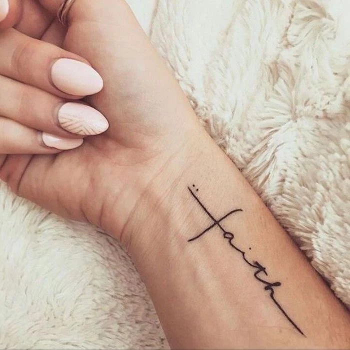 faith inscription, tattoos for women with meaning, pink nail polish, tattoo on the wrist, white fluffy blanket