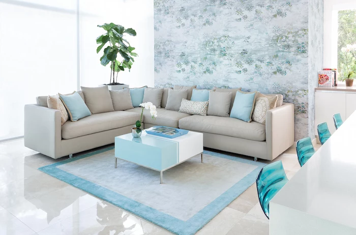 floral wallpaper, blue rug, blue and white coffee table, accent wall colors, beige sofa with blue throw pillows