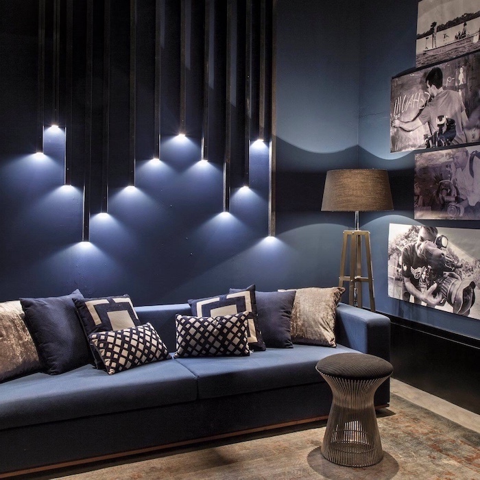 blue walls, geometrical 3d wall installation with lights, accent wall colors, blue sofa, framed photos