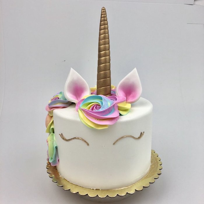 rainbow coloured roses on white fondant, gold horn, pink ears, rainbow unicorn cake