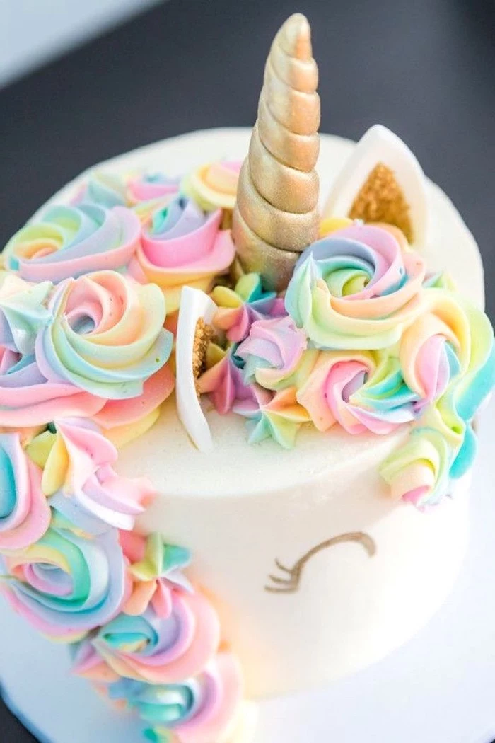 rainbow coloured roses on white fondant, gold horn and ears, how to make a unicorn cake
