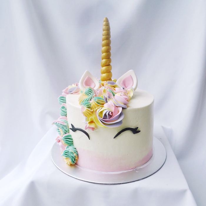 pink purple yellow and green roses on white fondant, gold horn, diy unicorn cake, white background