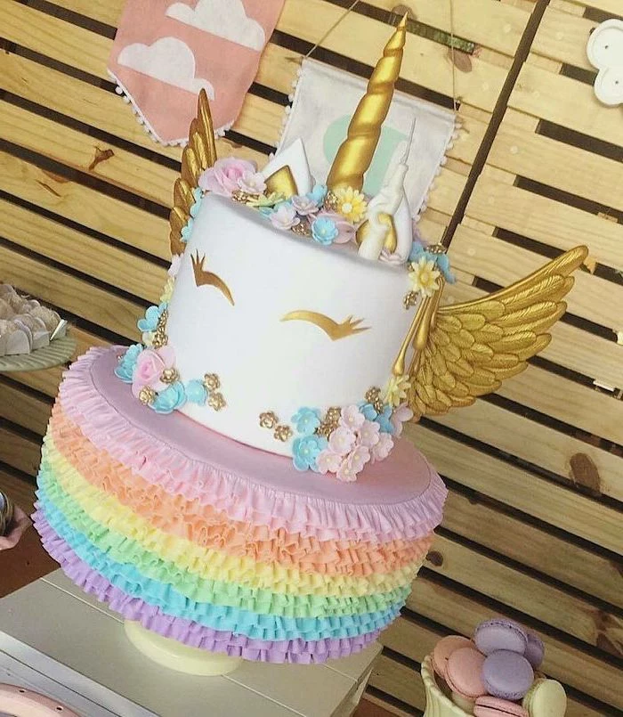gold horn and wings, unicorn cupcake cake, rainbow coloured roses first layer, pink and blue flowers
