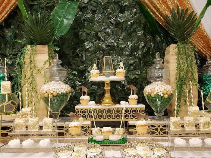greenery background, baby shower centerpieces boy, cake pops and cupcakes on the table and glass stands