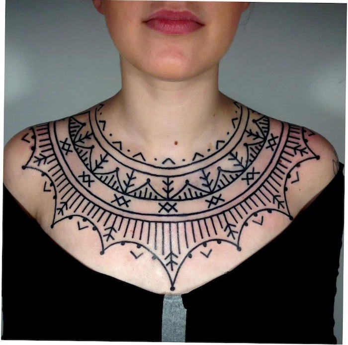 black top, blue background, rose chest tattoo, symmetrical geometrical shapes tattoo