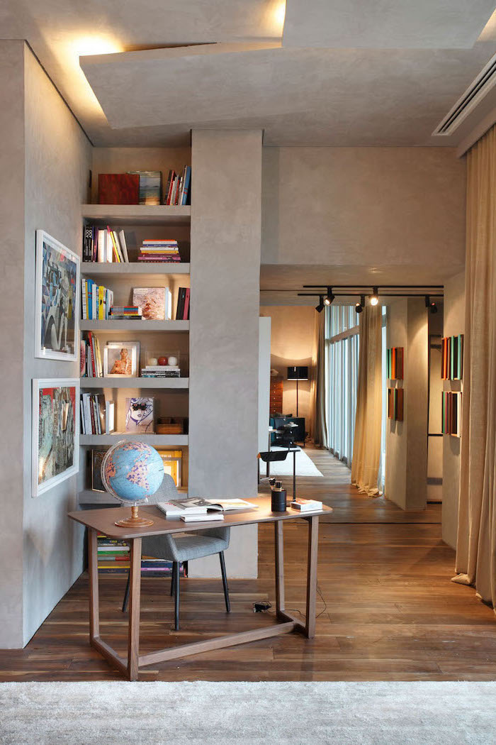 grey walls and rug, wooden desk, bookcase with lots of books, grey chair, desk ideas