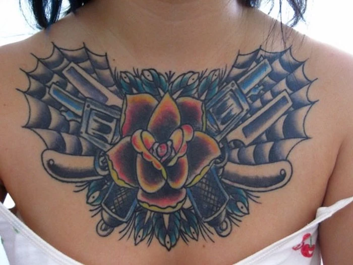 small chest tattoos, large red and yellow rose with guns and webs, white top and background