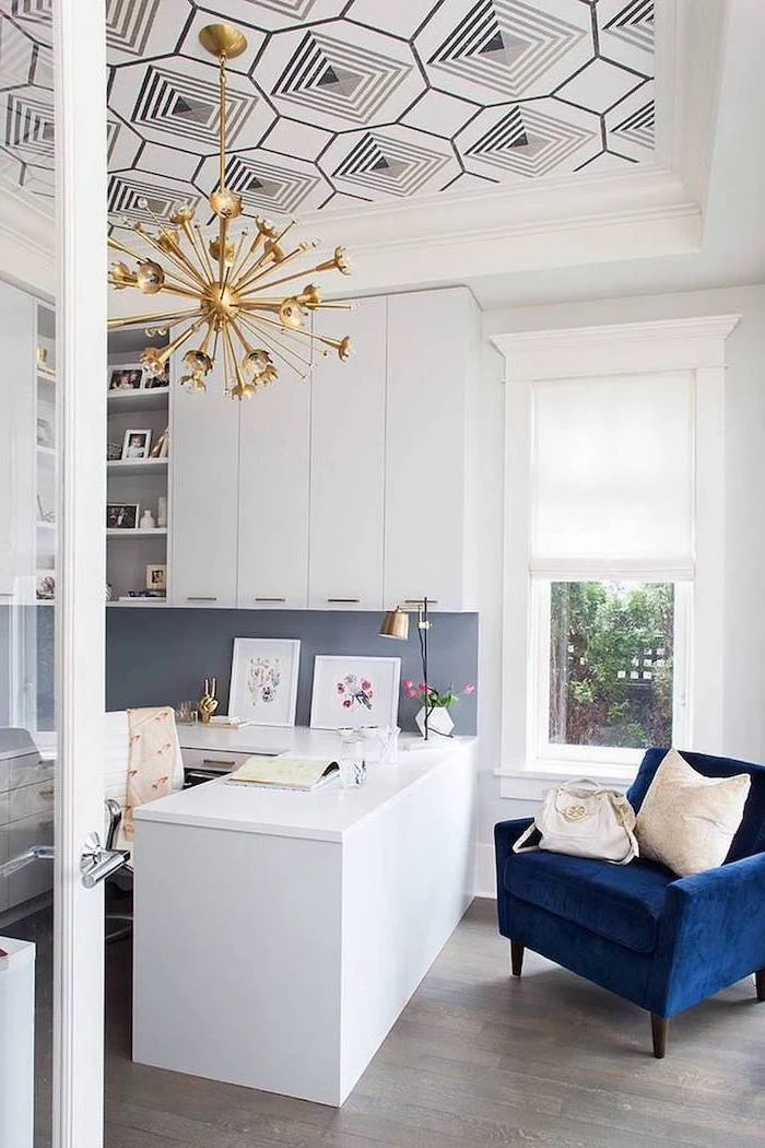 navy blue velvet armchair, small home office ideas, metal golden hanging chandelier, white desk and cabinets