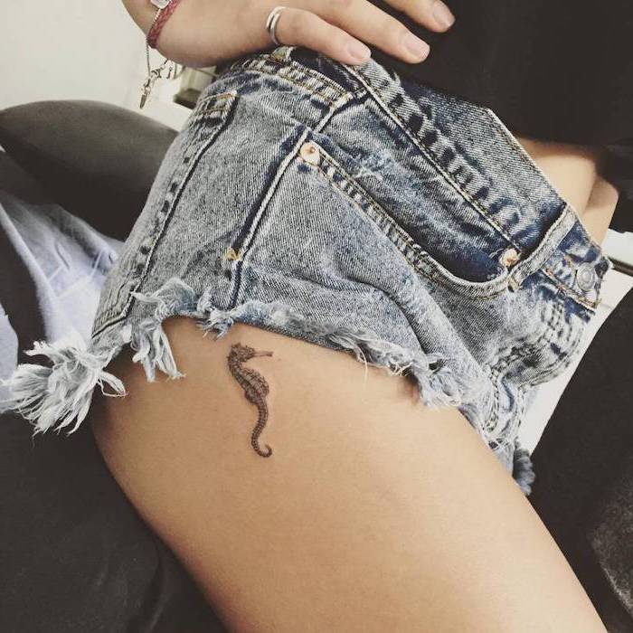 seahorse tattoo on the thigh, arm tattoos for girls, short jeans and black top