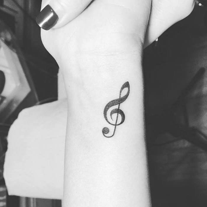 black background, cute tattoos for girls, music key, tattoo on the wrist