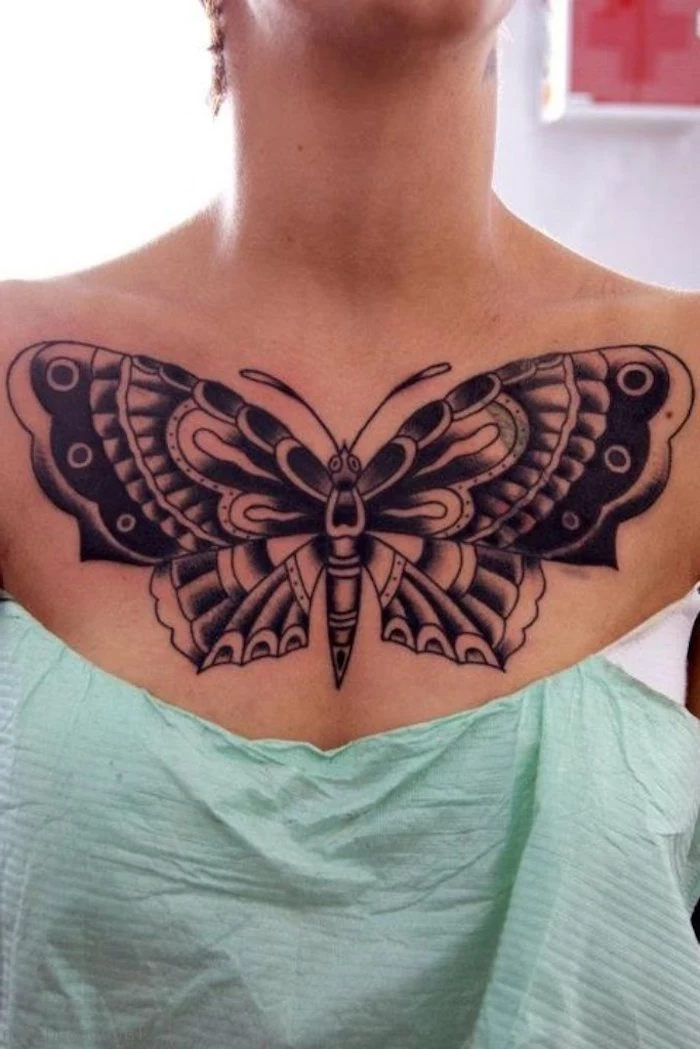 tattoos for women with meaning, large black butterfly, green paper, white top and background, tattoo designs for womens chest