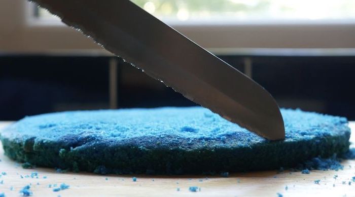 blue batter cut with a knife, crust on a wooden countertop, unicorn cupcakes