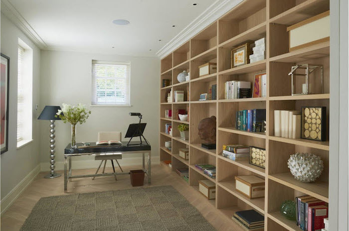 large bookcase, black metal desk, white chair, standing lamp, cute office decor, beige rug on a wooden floor