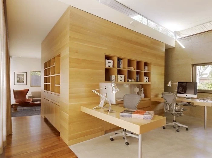 large wooden bookcase and desks, grey mesh chairs, cute office decor, brown leather armchair