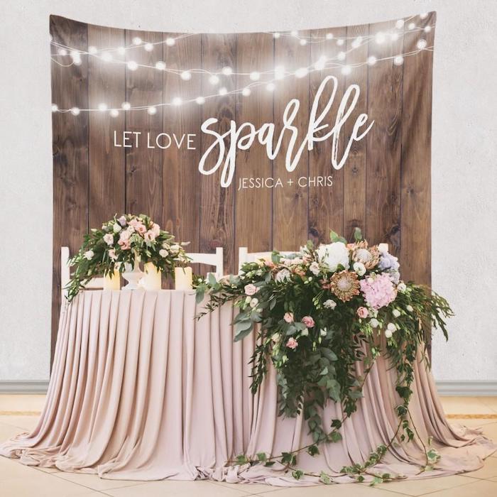 wooden backdrop with fairy lights, large pink and green flower arrangements on the table, flower bouquet in a vase, wedding table settings