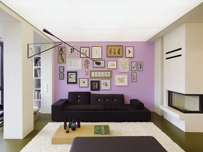 light purple wall with lots of photos and pictures, black sofa, wall painting ideas, wooden coffee table