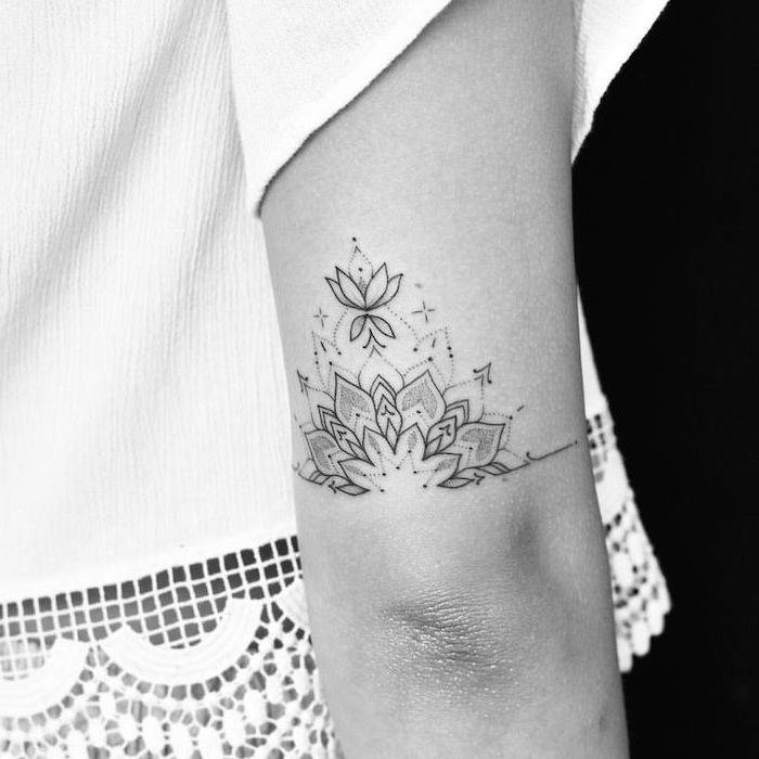 lotus flower, tattoo above the elbow, white top, small tattoo ideas for women, black background