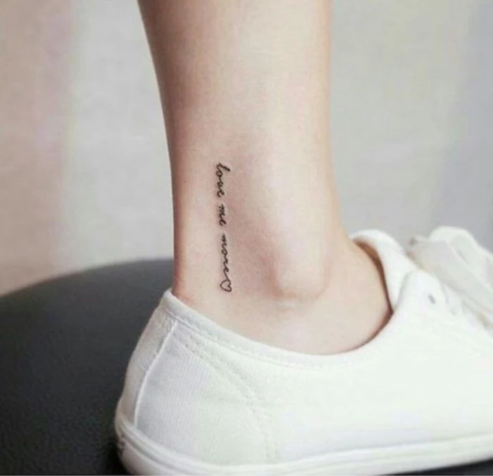 chest tattoos for females, love me more inscription, white sneakers, tattoo on the ankle
