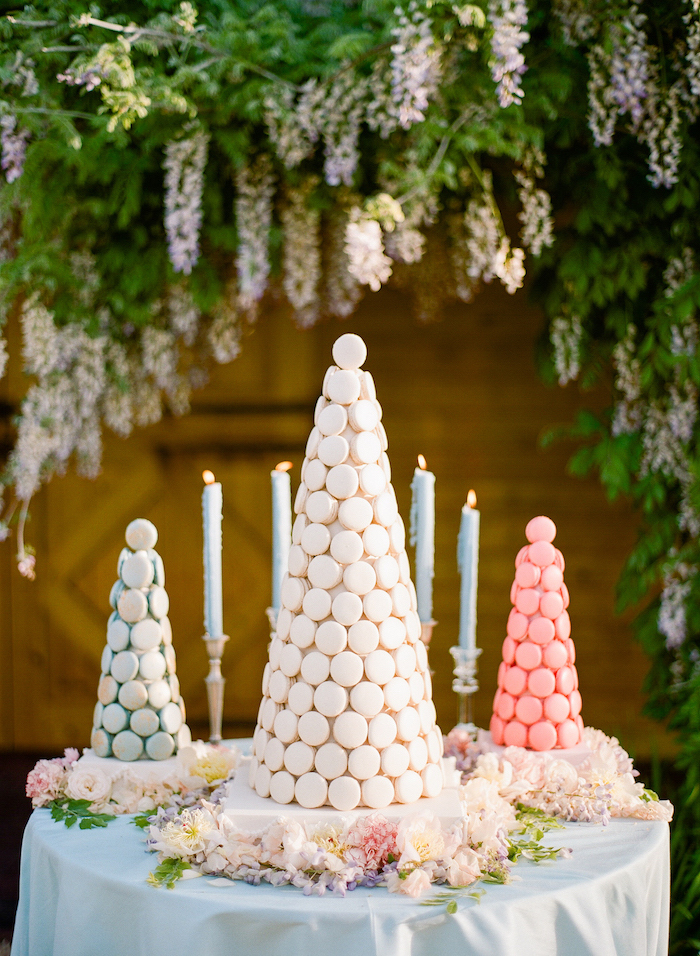 trees made from macaroons, candles on candlesticks, flower arrangements on the table, flowers hanging above, wedding table decorations
