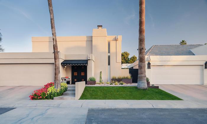 tall palm trees, landscape lighting ideas, small grass patch, flower bed with yellow and pink flowers