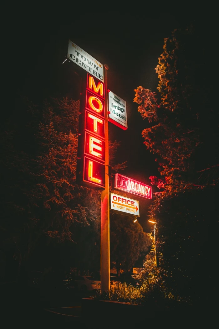 large motel sign, pretty iphone wallpaper, neon signs, tall trees and a pathway
