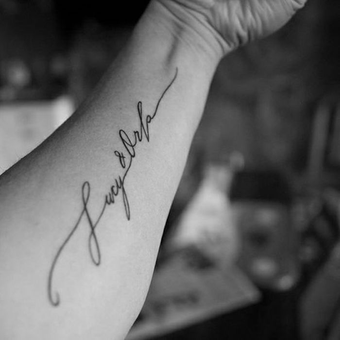 names inscription, forearm tattoo, blurred background, tattoo ideas with meaning