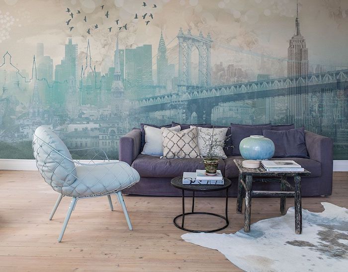 new york skyline wallpaper, purple velvet sofa, accent wall, blue armchair, wooden floor