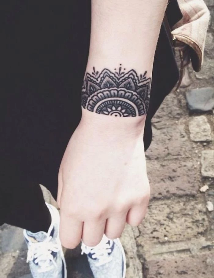 symmetrical wrist tattoo, paved path, small tattoos with meaning, black jeans and pants