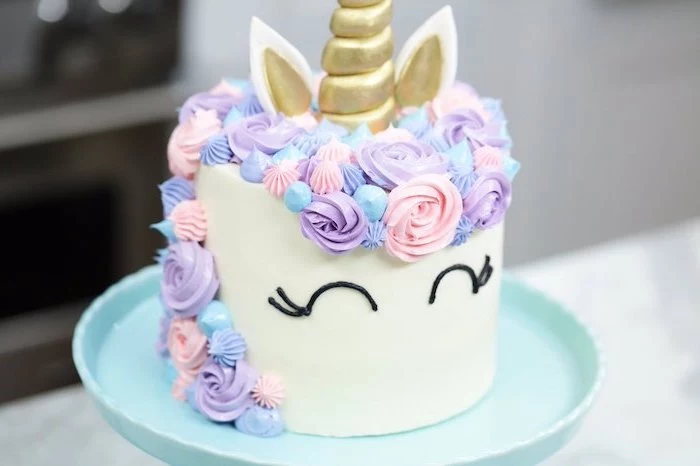 blue cake stand, unicorn cake pictures, pink purple and blue roses on white fondant, gold horn and ears
