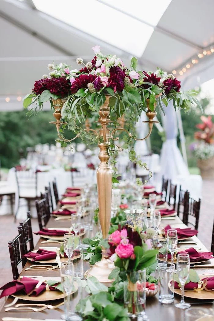 pink and red flower bouquets in a candelabrum, red napkins on the table, wedding ceremony decorations