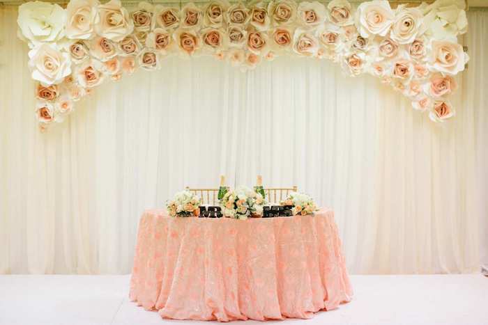 mr and mrs metal sign, white and pink paper roses, flower bouquets in vases on the table, rustic wedding centrepieces